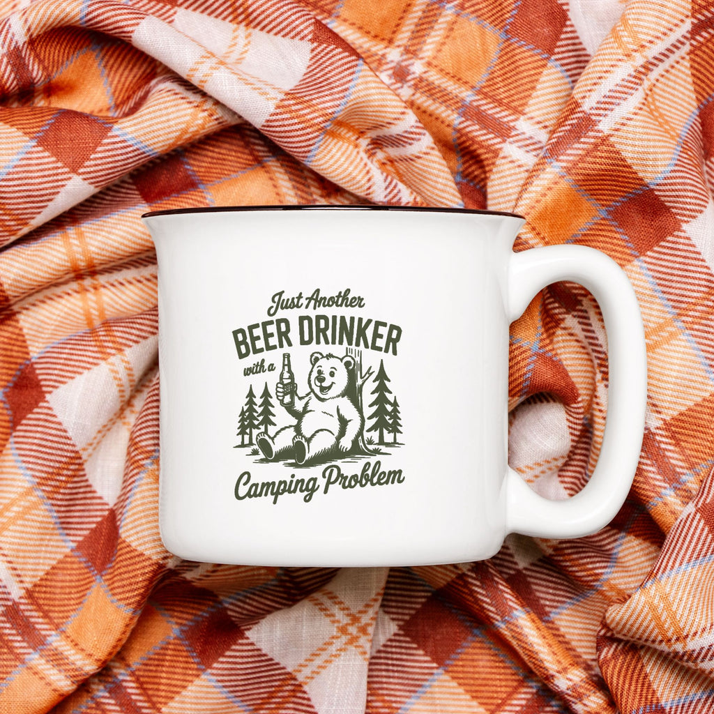 White mug with bear graphic and text on plaid fabric