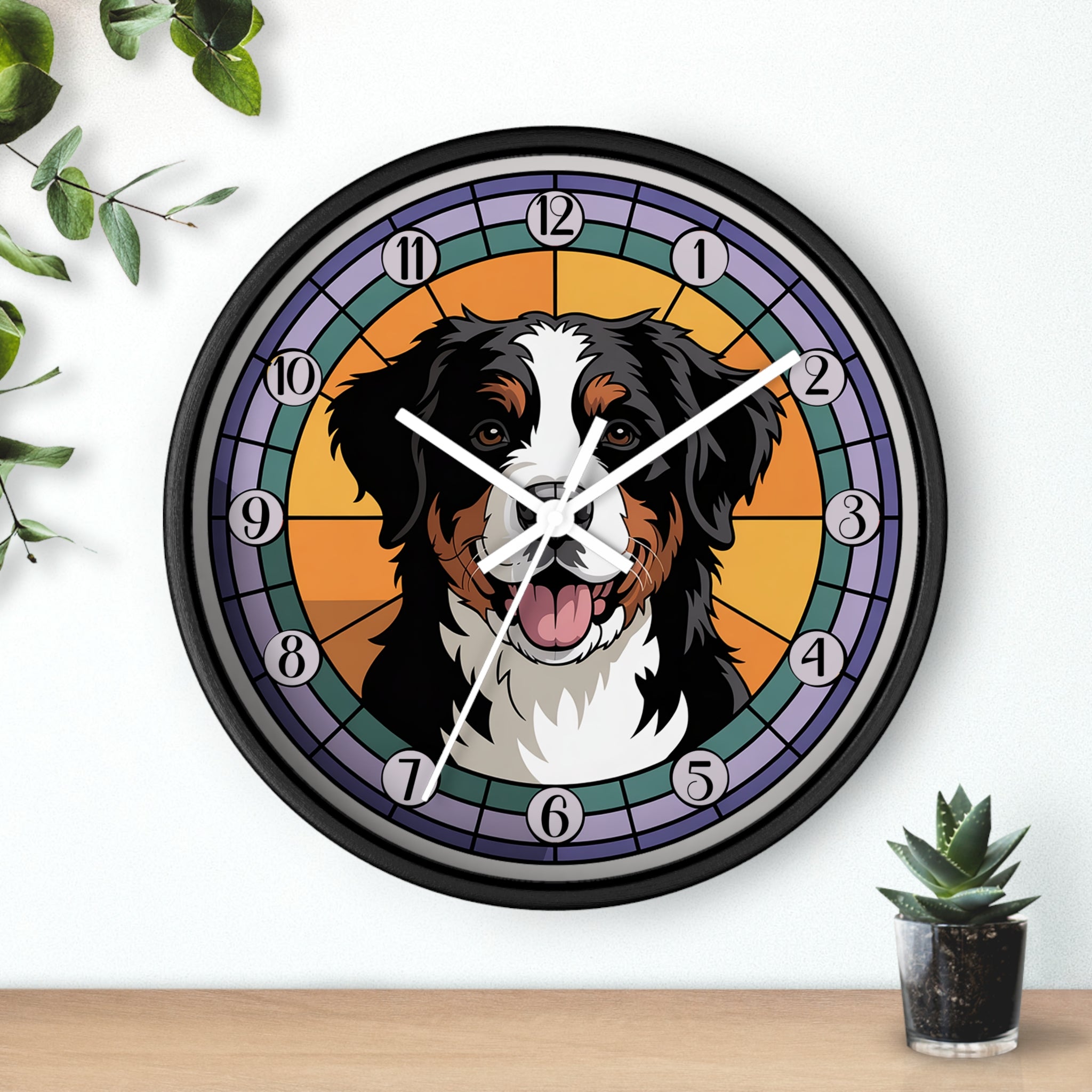 Wall clock with a dog's face on a colorful background, placed on a wooden surface with a plant.