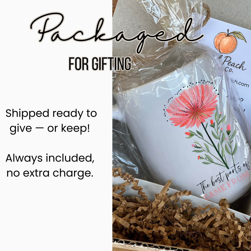 15oz. white mug with a hand drawn floral design and text, wrapped in clear plastic and in a white gift box with brown paper ready for gifting