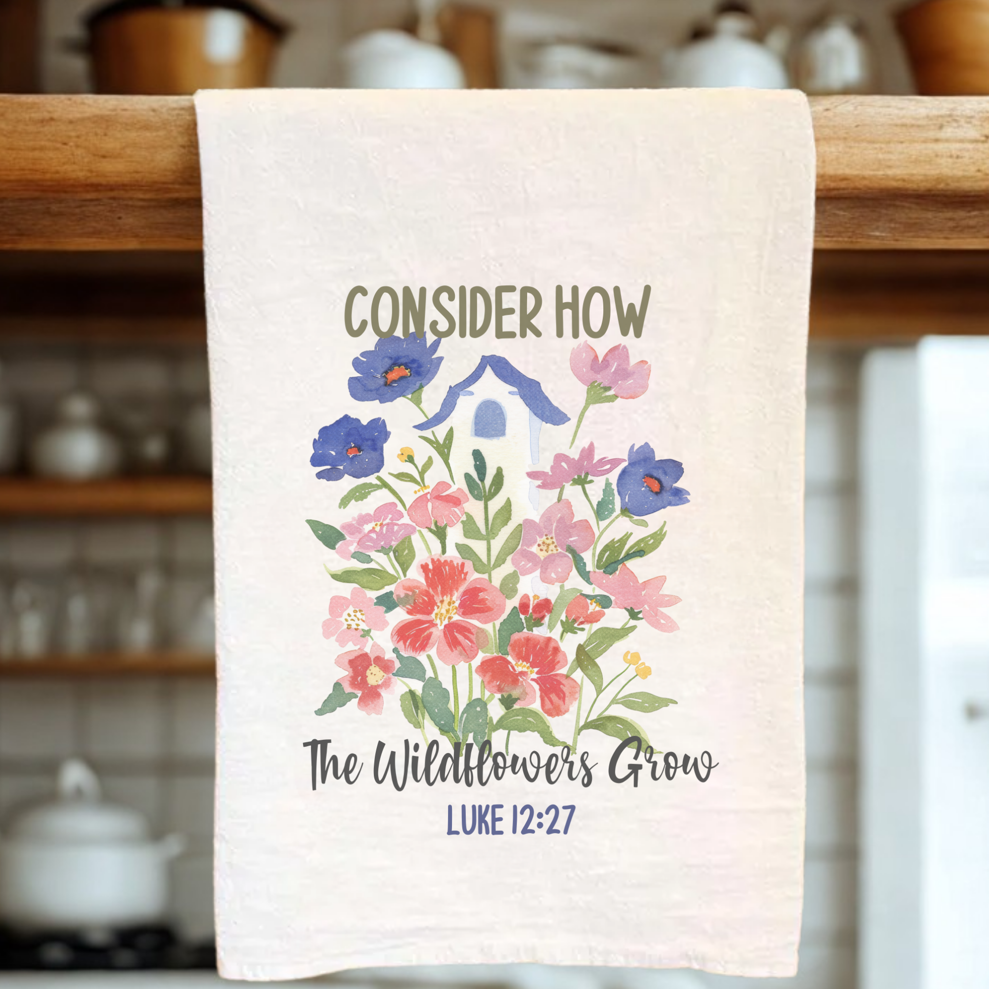 Kitchen towel with floral design and text on a wooden rack