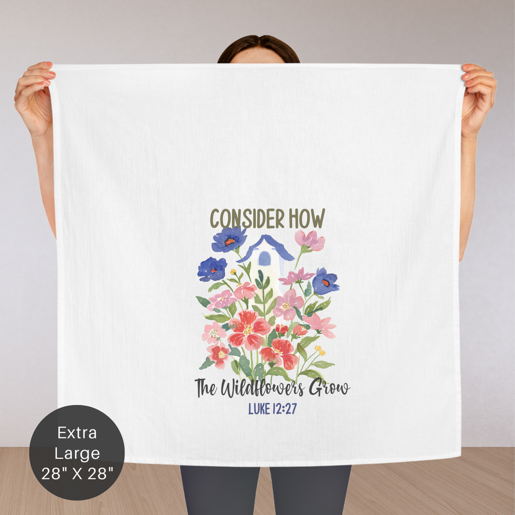 Person holding an extra large white tea towel with floral design and text.