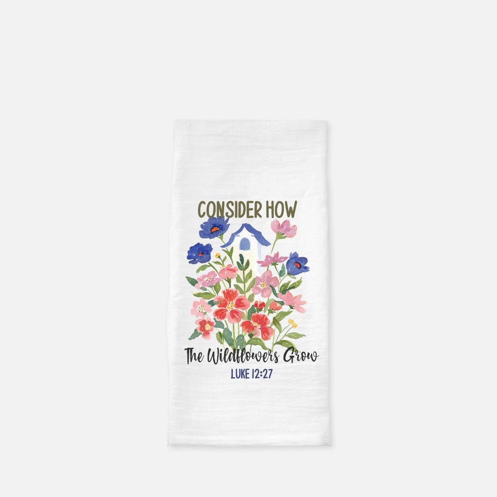 White tea towel with floral design and text on a white background