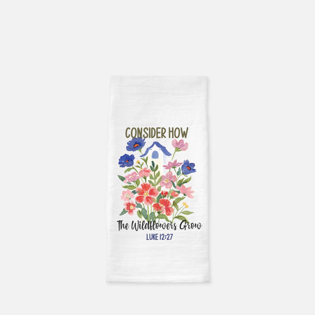 White tea towel with floral design and text on a white background