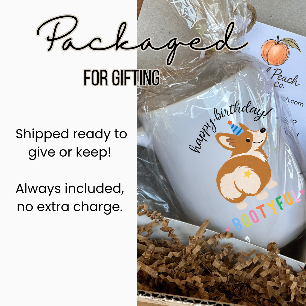 White mug with a dog illustration and text, wrapped in clear plastic with brown paper underneath.