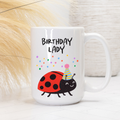 White mug with cartoon ladybug and 'Birthday Lady' text on a light background