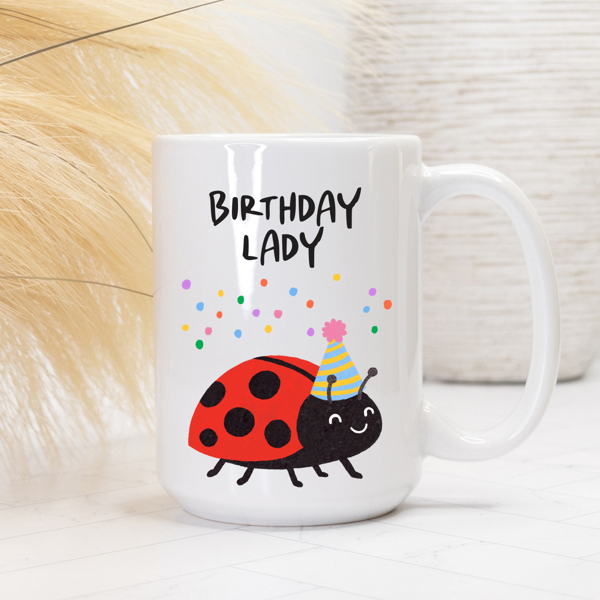 White mug with cartoon ladybug and 'Birthday Lady' text on a light background