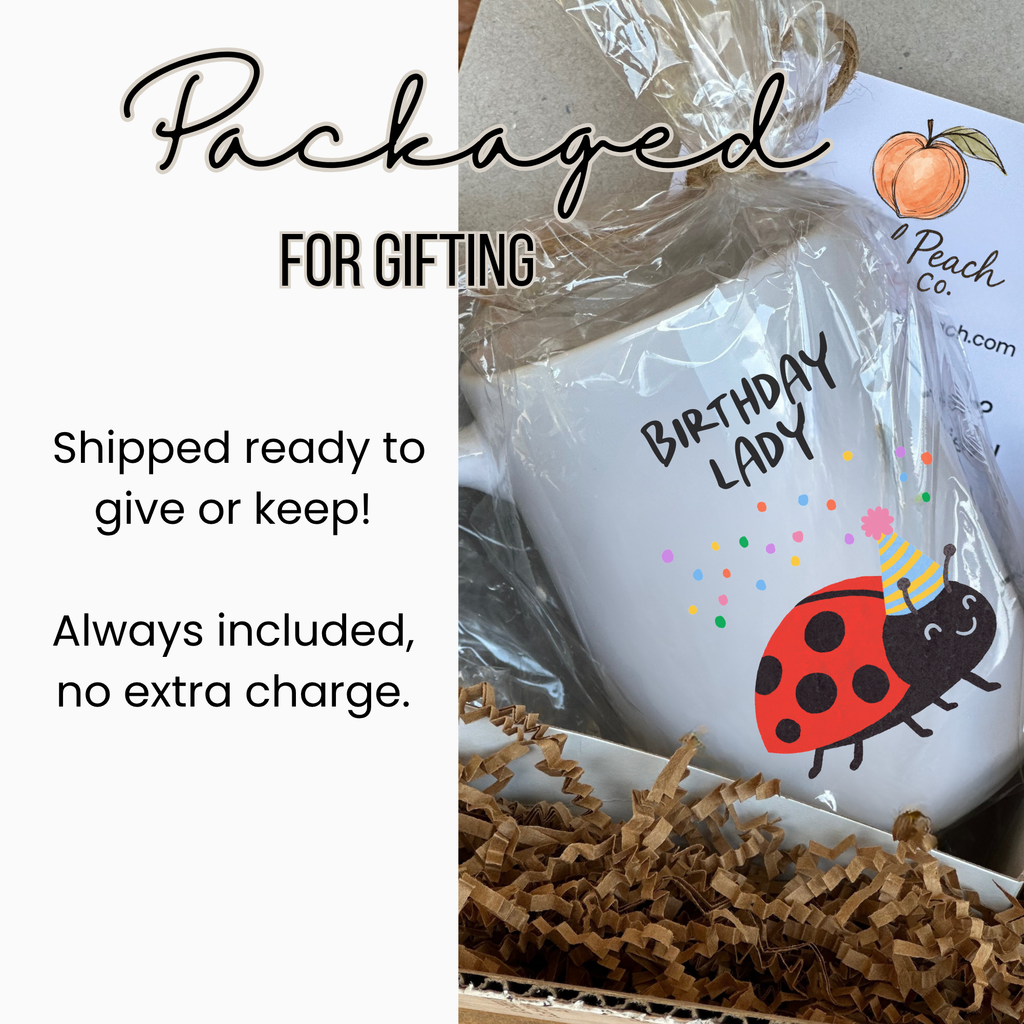 Gift-wrapped mug with 'Birthday Lady' and ladybug design, labeled 'Artful Peach Co'.