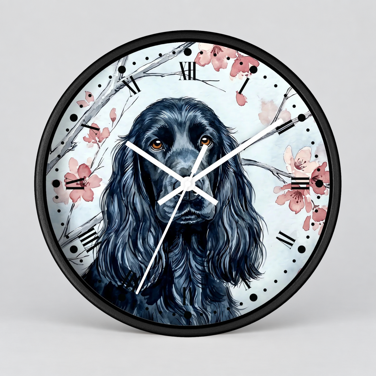 Round wall clock with a black frame and a printed illustration of a black long-haired dog on a light background with pink flowers and branch details. White clock hands and black Roman numerals are visible.