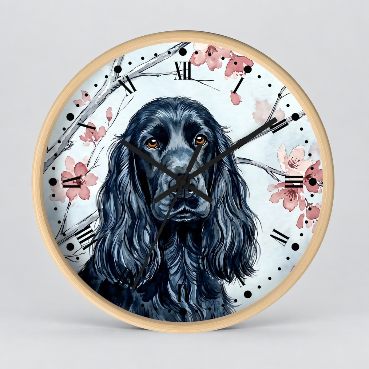 Round wall clock with a light wood frame featuring a watercolor illustration of a black long-haired dog, Roman numerals, and pink cherry blossoms on a light gray background.