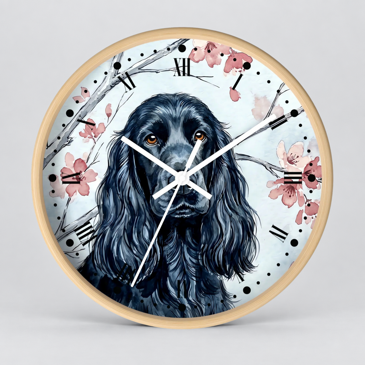 Round wall clock with a light wood frame featuring a painted black dog portrait, pink blossoms, and black Roman numerals on a pale blue background.