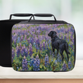 Black lunch bag with a painterly design of a black dog in a field of purple flowers on a white background