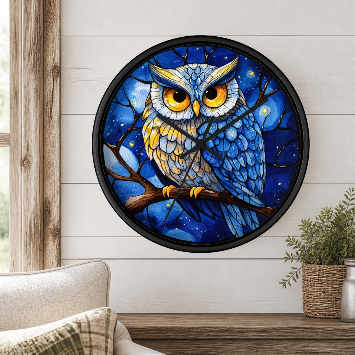 Round wall clock with a black frame and a colorful owl illustration on the face, mounted on a white shiplap wall above a wooden mantel with a plant and part of a sofa visible.