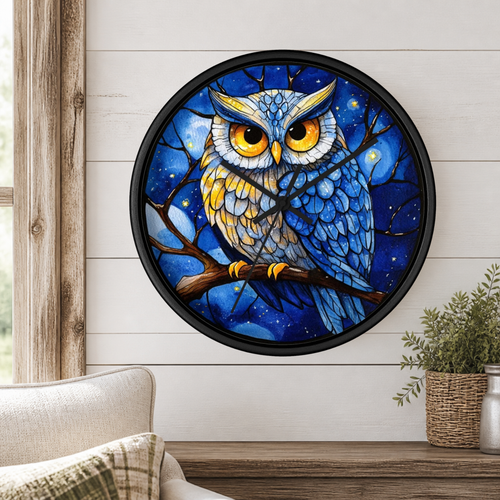 Round wall clock with a black frame and a colorful owl illustration on the face, mounted on a white shiplap wall above a wooden mantel with a plant and part of a sofa visible.