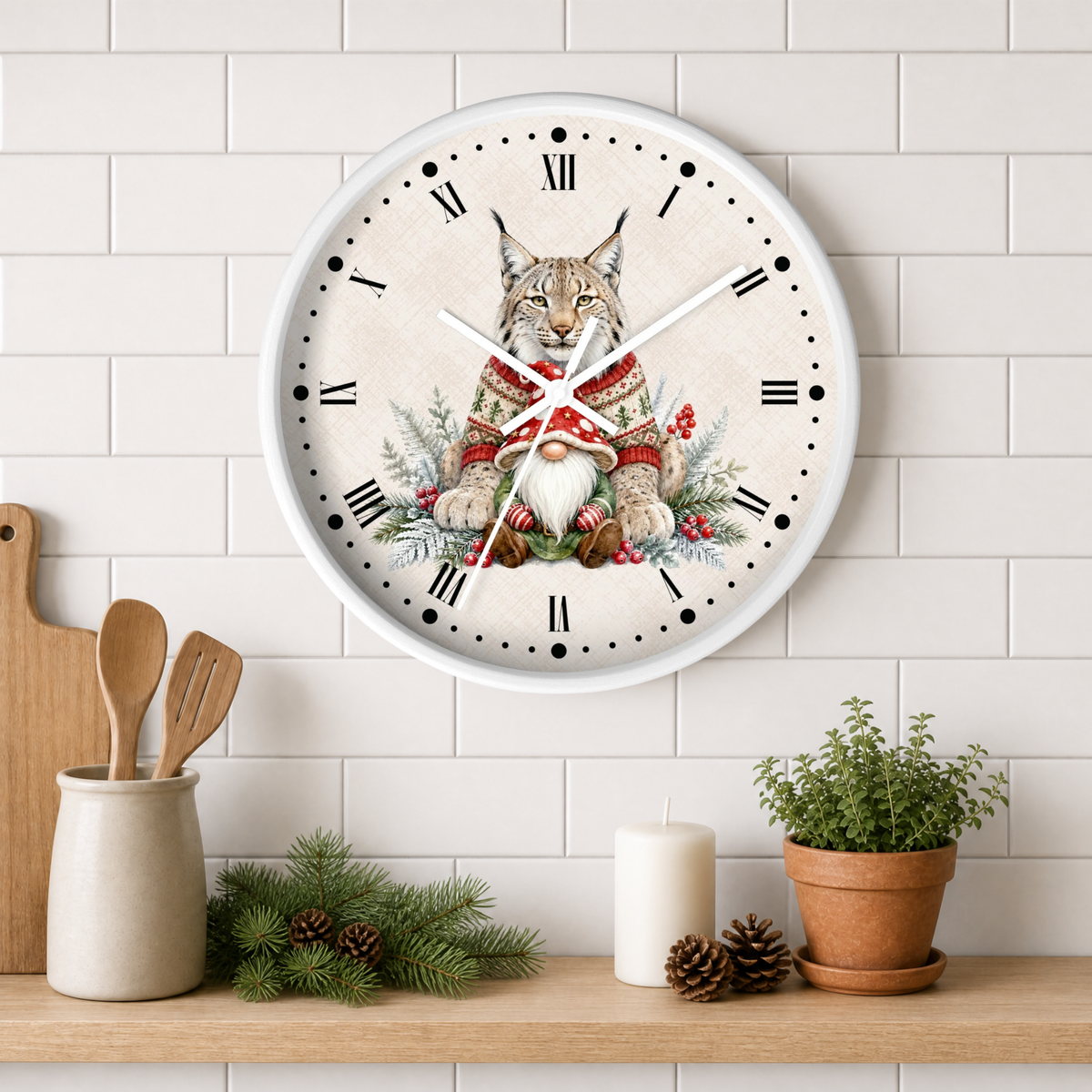 A round wall clock with a white frame hangs on a white subway tile wall above a wooden shelf. The clock face features a detailed illustration of a lynx wearing a red and green knit sweater and a white bearded gnome, surrounded by pine branches and red berries.