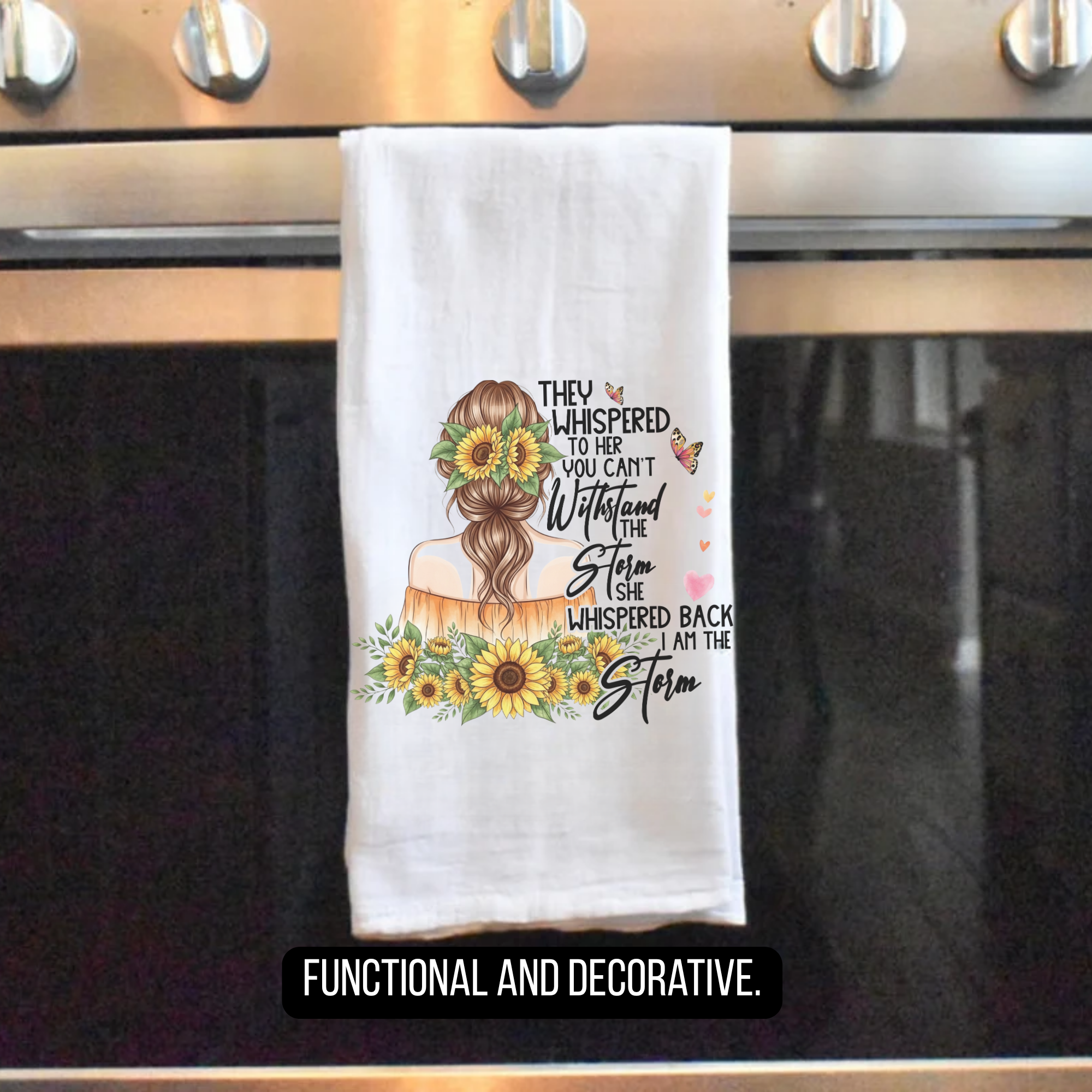 Decorative towel with sunflower design and text hanging on a stove handle.