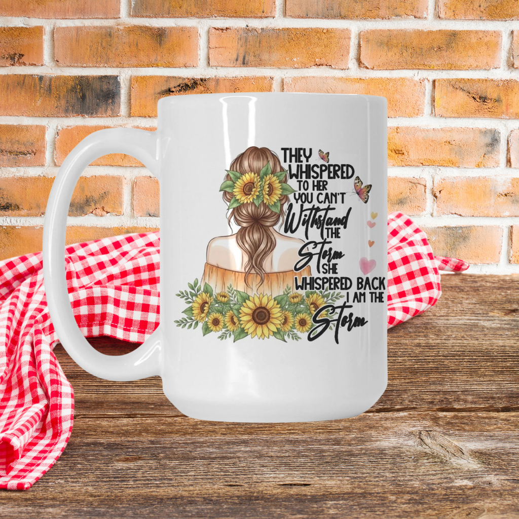 White mug with a design of a woman with a bun, sunflowers, and text on a wooden picnic table with a brick wall background.