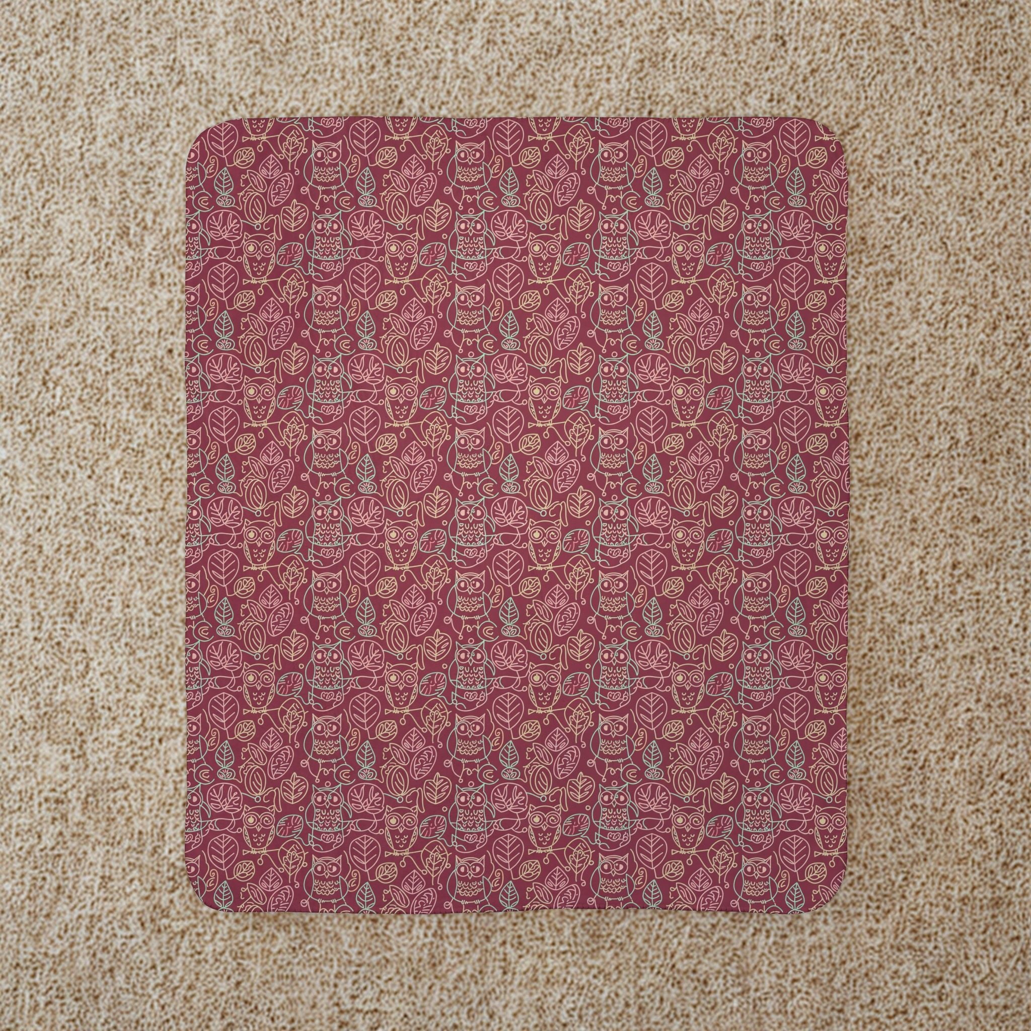 Patterned owl blanket on a beige carpet