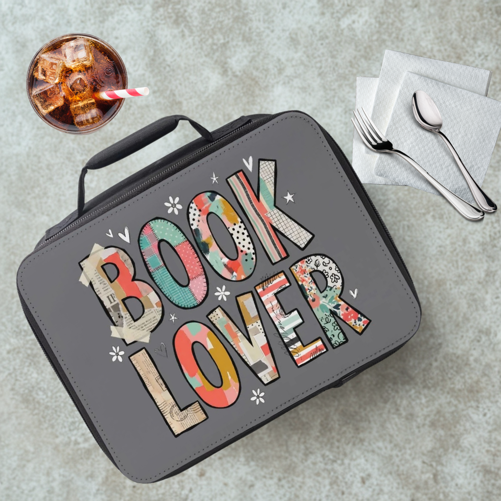 Lunch bag with 'BOOK LOVER' patterned text on a cafeteria table with a drink and utensils.