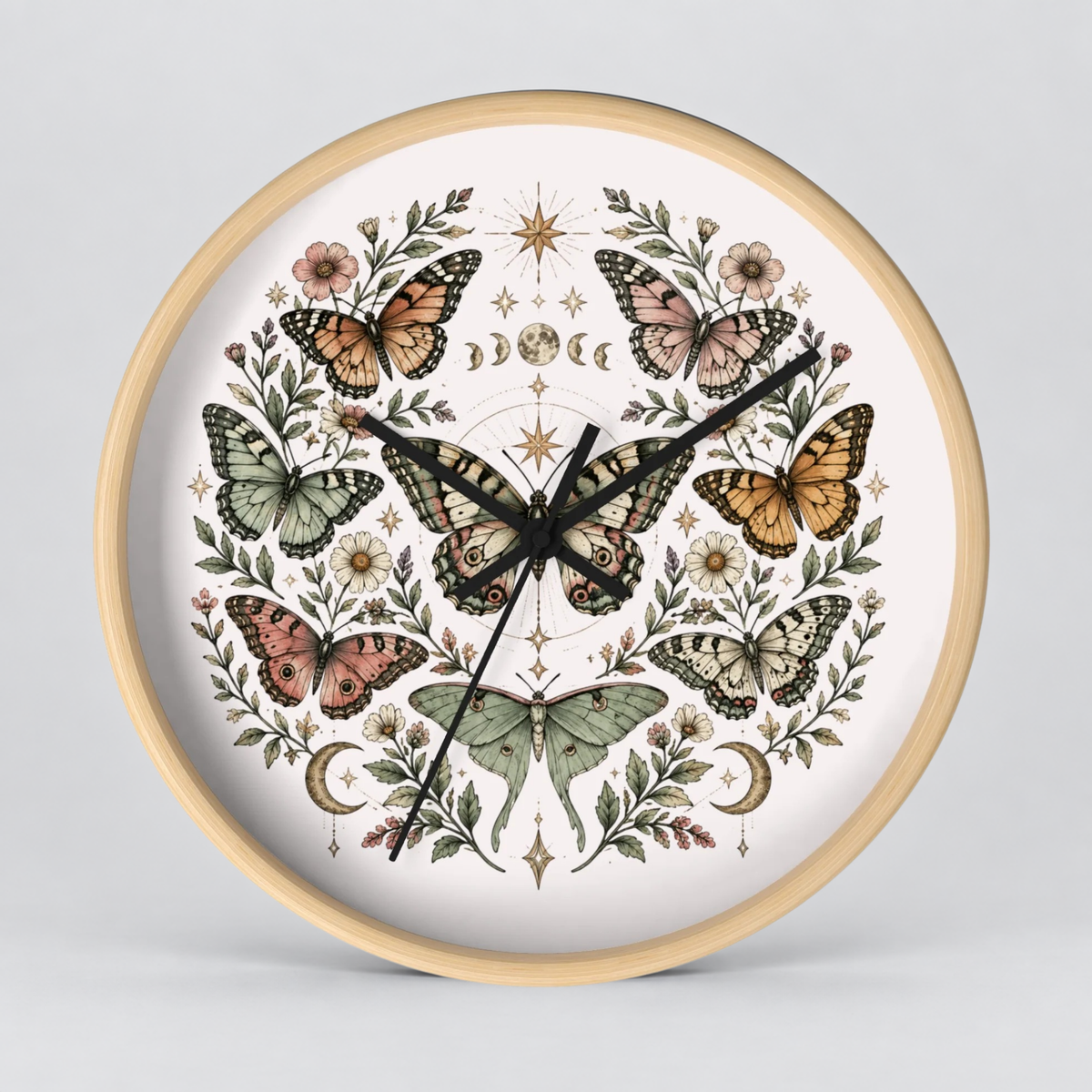 Round wall clock with a light natural wood frame and a white face, decorated with an intricate symmetrical illustration of butterflies, flowers, leaves, and celestial symbols in muted earthy tones.