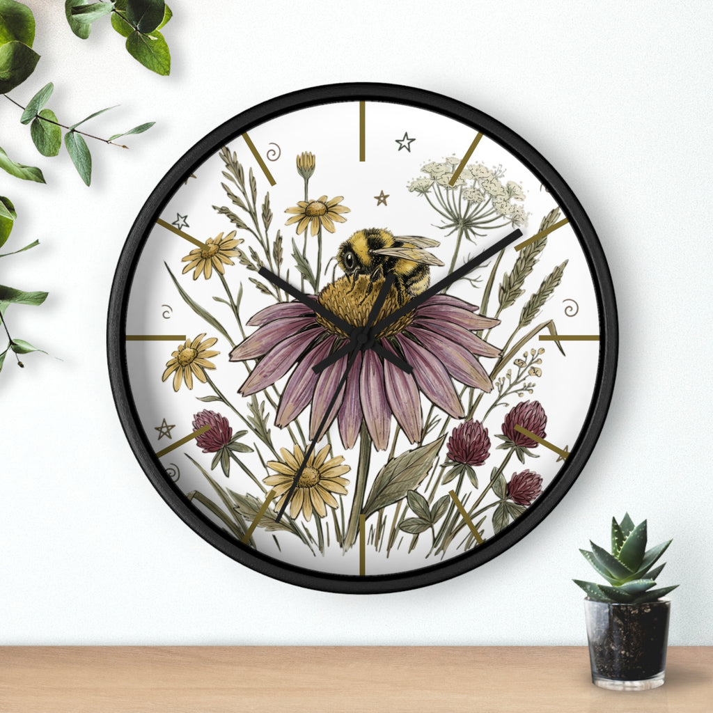 Round black decorative wall clock with a hand drawn bee and flower design on a white background