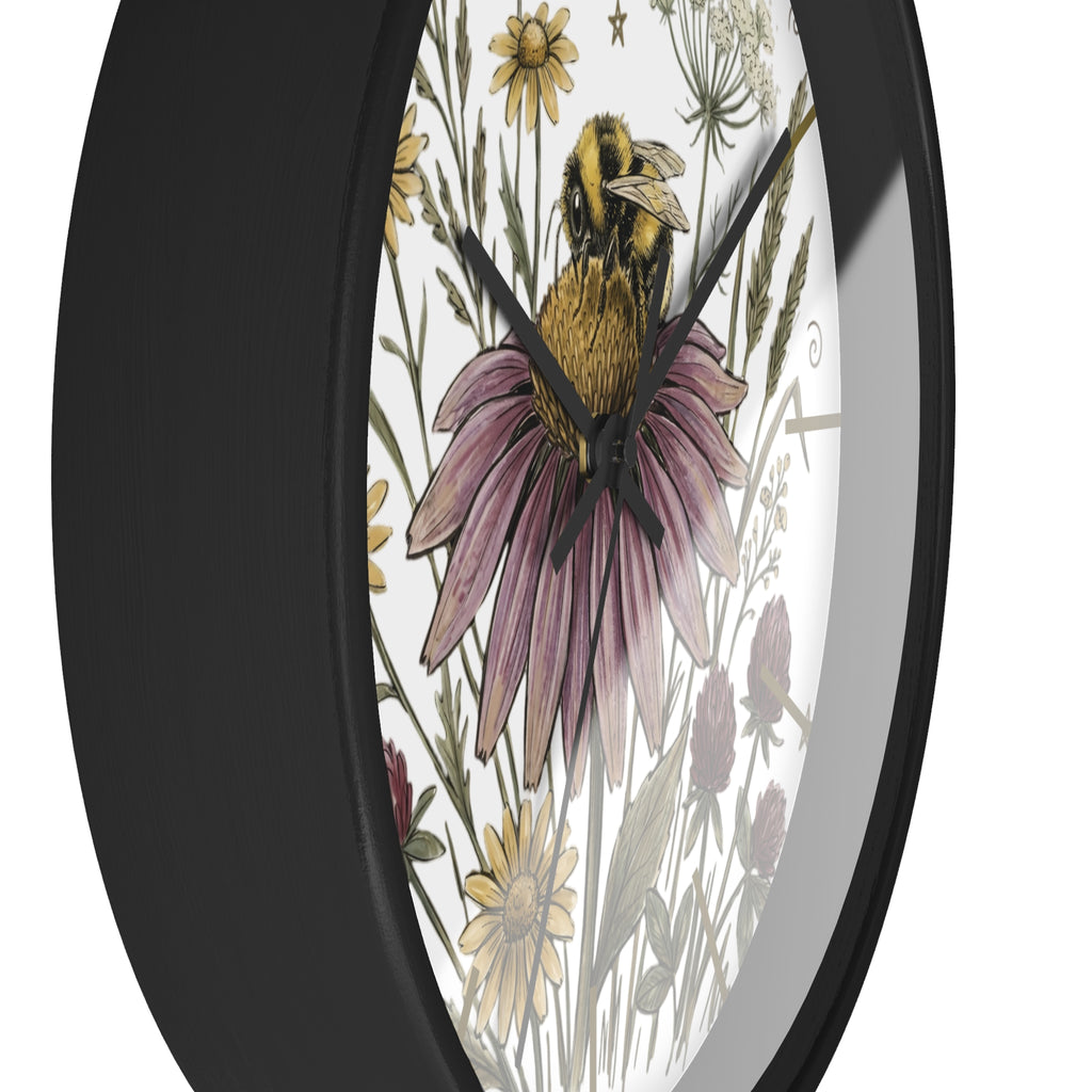 Side view of a round black wall clock with a design of a bee on a flower and surrounding plants.