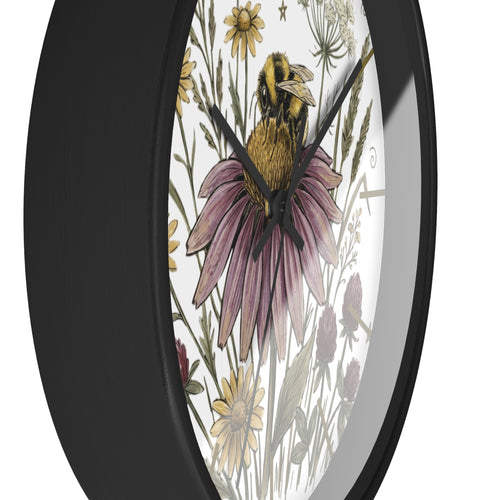 Side view of a round black wall clock with a design of a bee on a flower and surrounding plants.