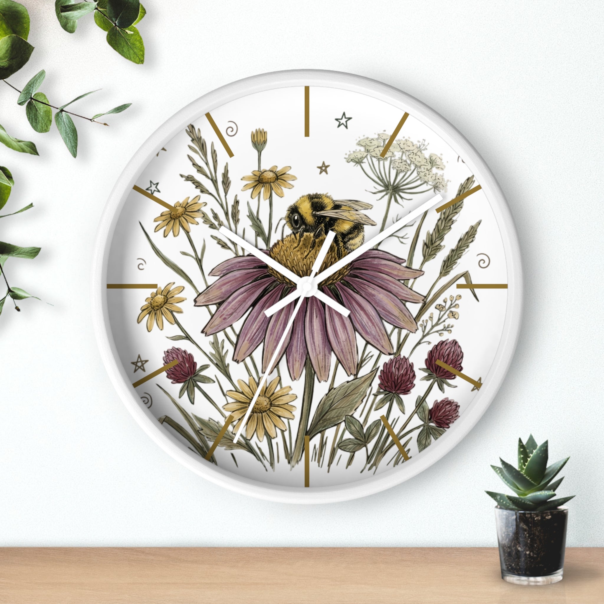 Round white decorative wall clock with  a hand drawn floral and bee design on a white background