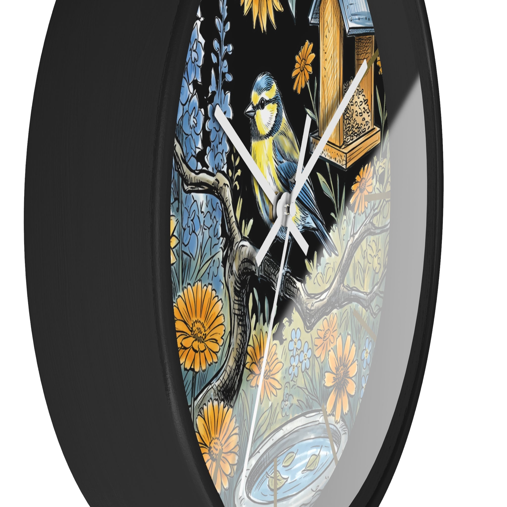 Side view of round black decorative wall clock with white hands and bird and floral design on a black background