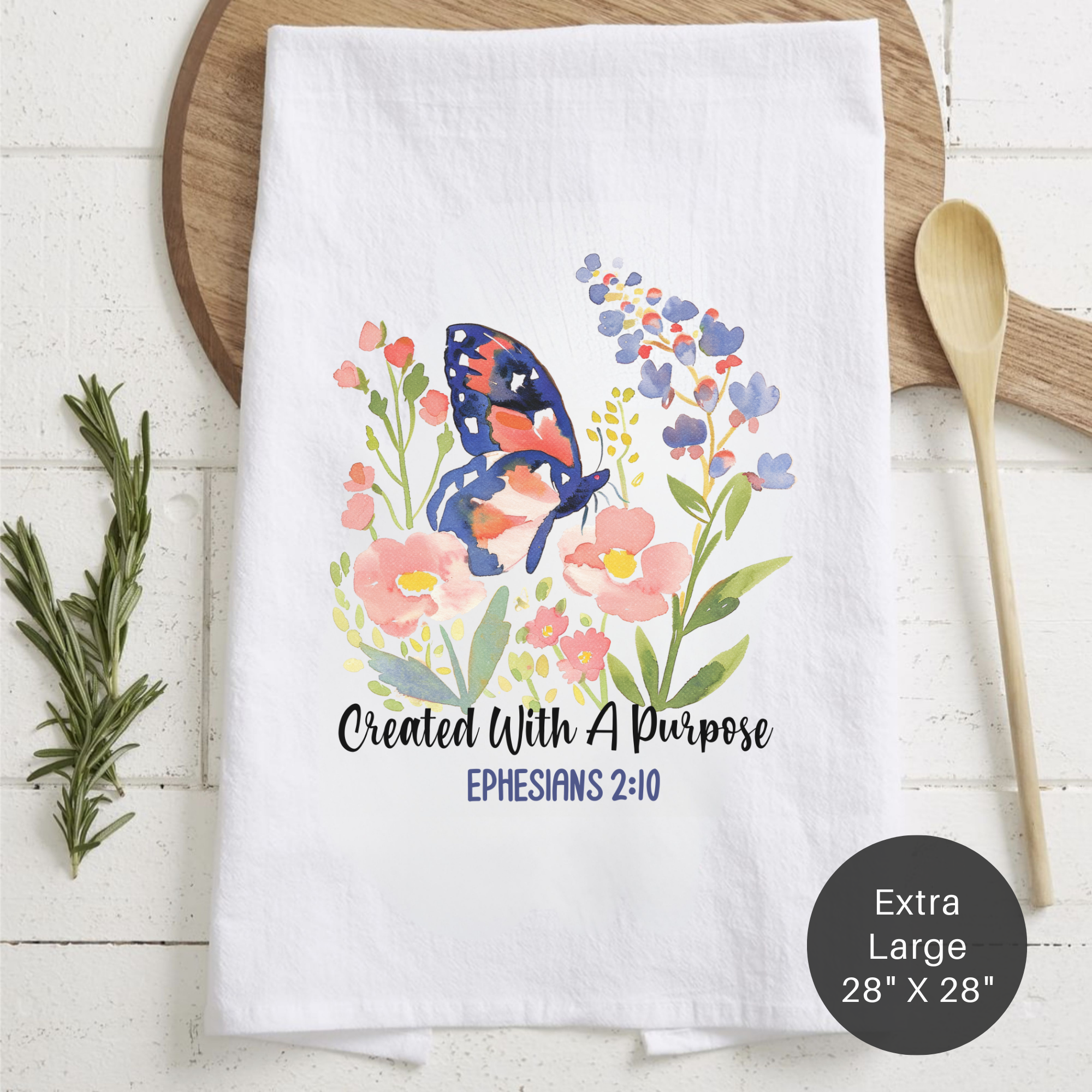 Floral tea towel with butterfly design and text on a wooden surface