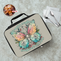 Lunch bag with butterfly design and text on a cafeteria table with a drink and utensils.