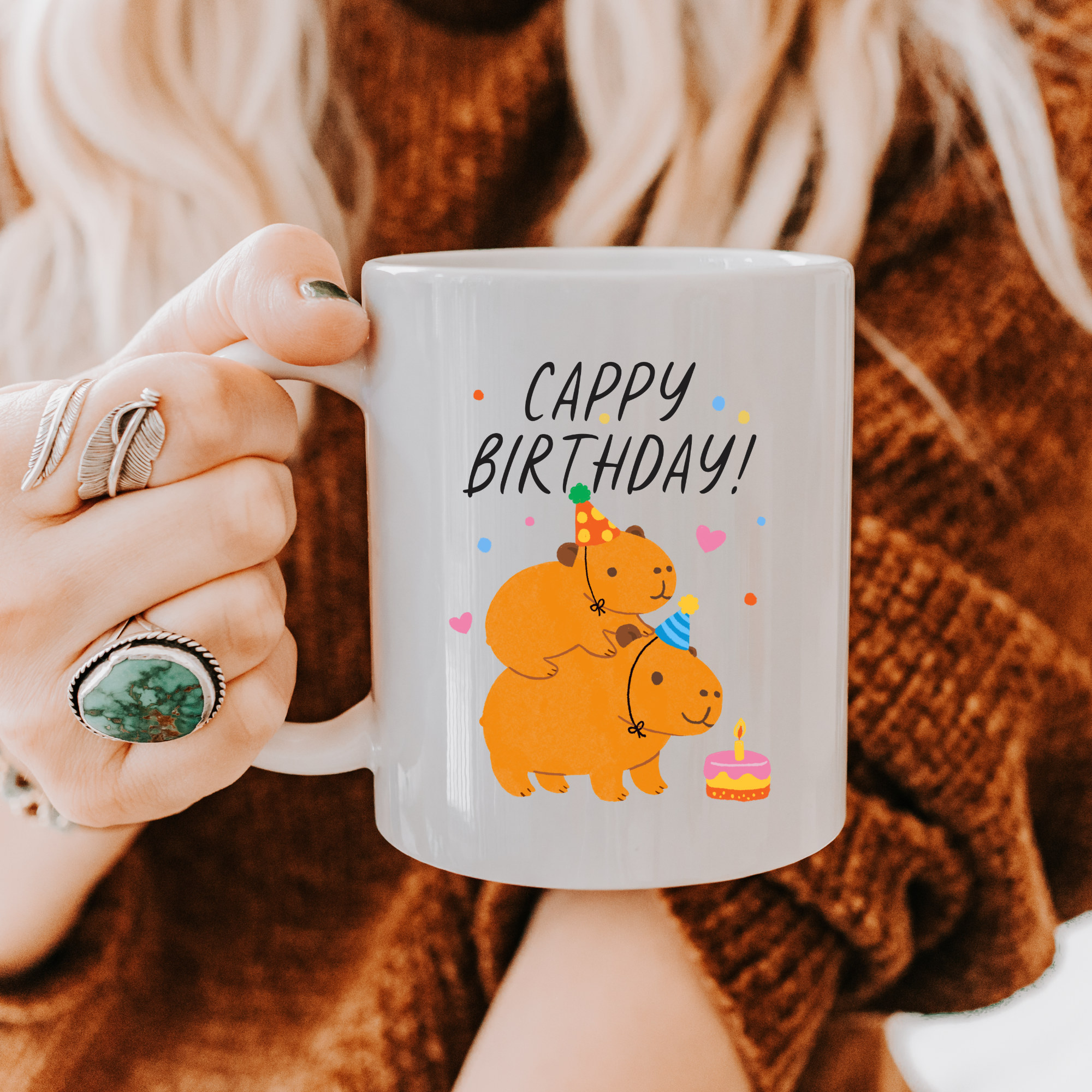 Person holding a mug with birthday design and text