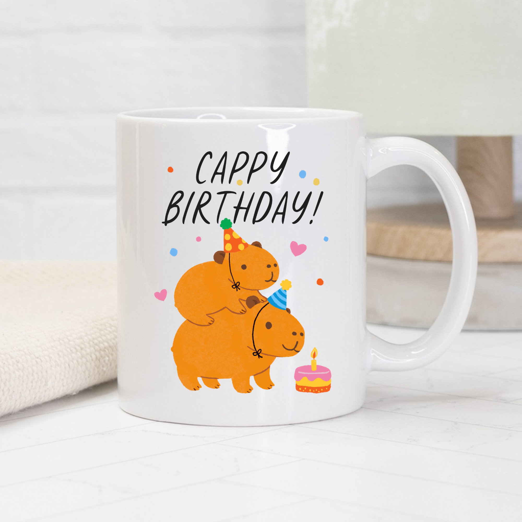 White mug with cartoon Capybaras and 'Cappy Birthday!' text on a light background