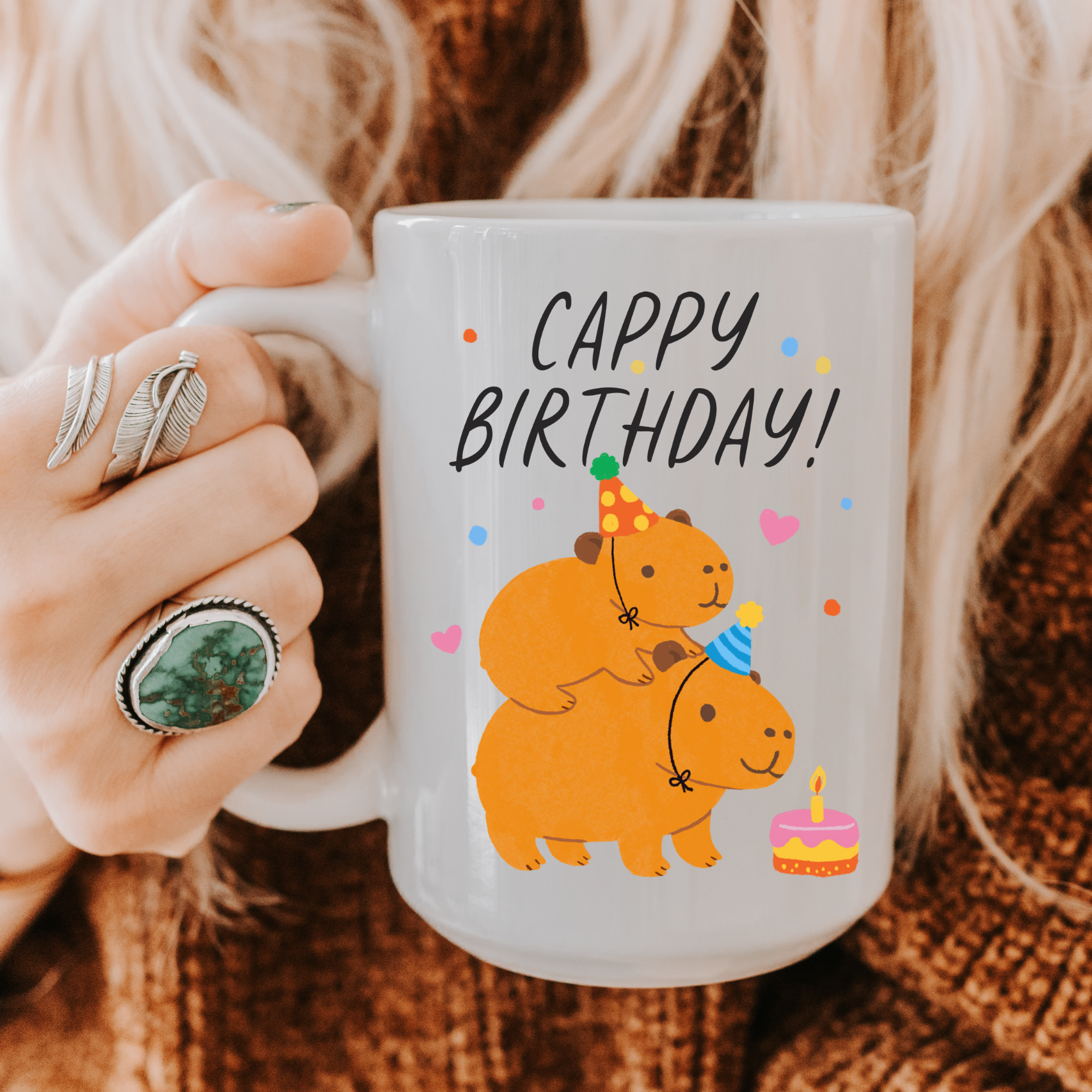 Person holding a mug with cartoon Capybaras and 'Cappy Birthday!' text