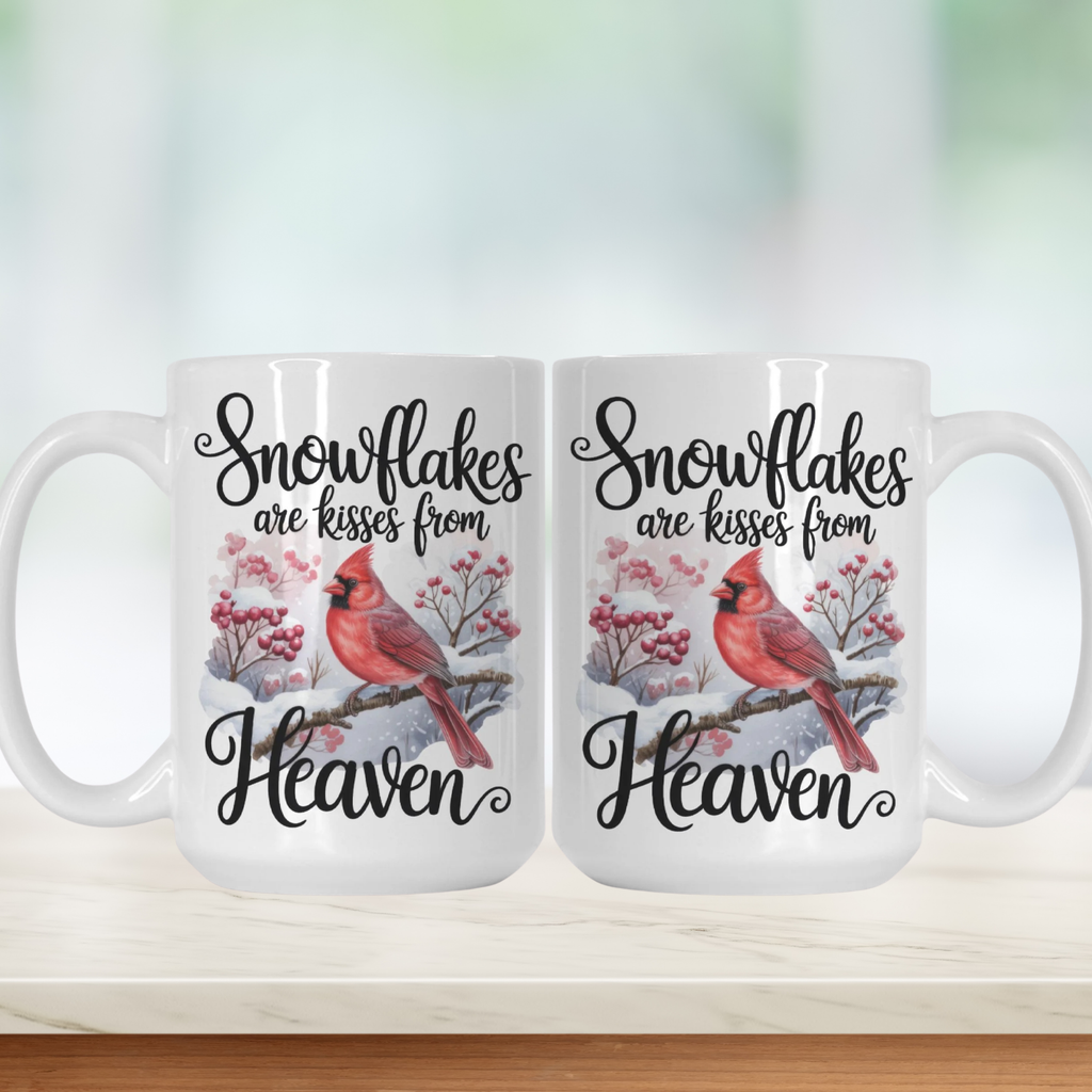 Two white mugs with cardinal birds and snowflake design on a light background
