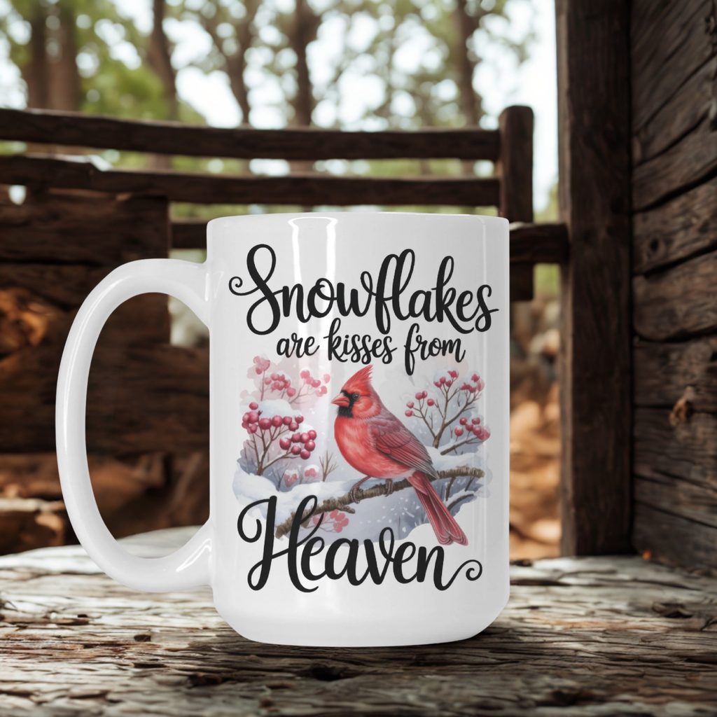 White mug with a red cardinal and snowflake design, placed on a wooden surface outdoors.