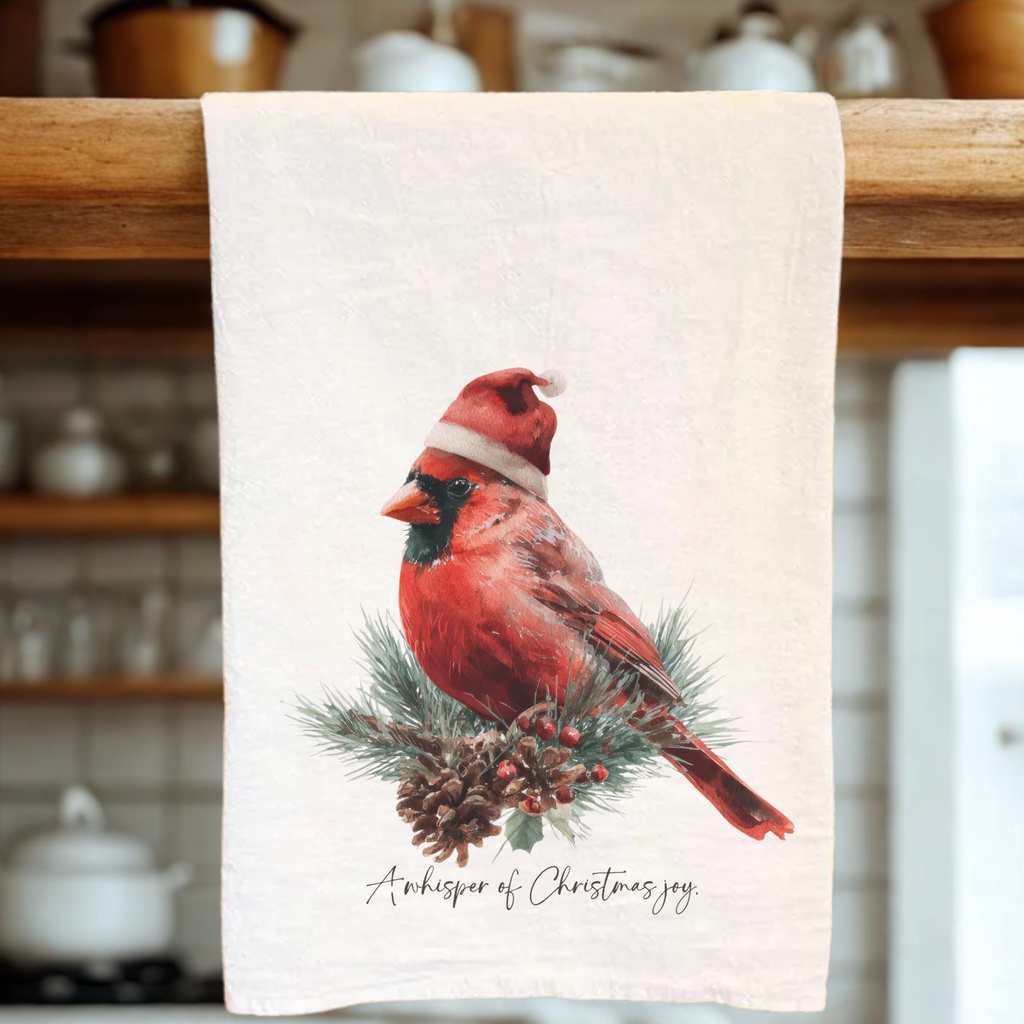 Towel with a red cardinal wearing a Santa hat on a wooden rack.