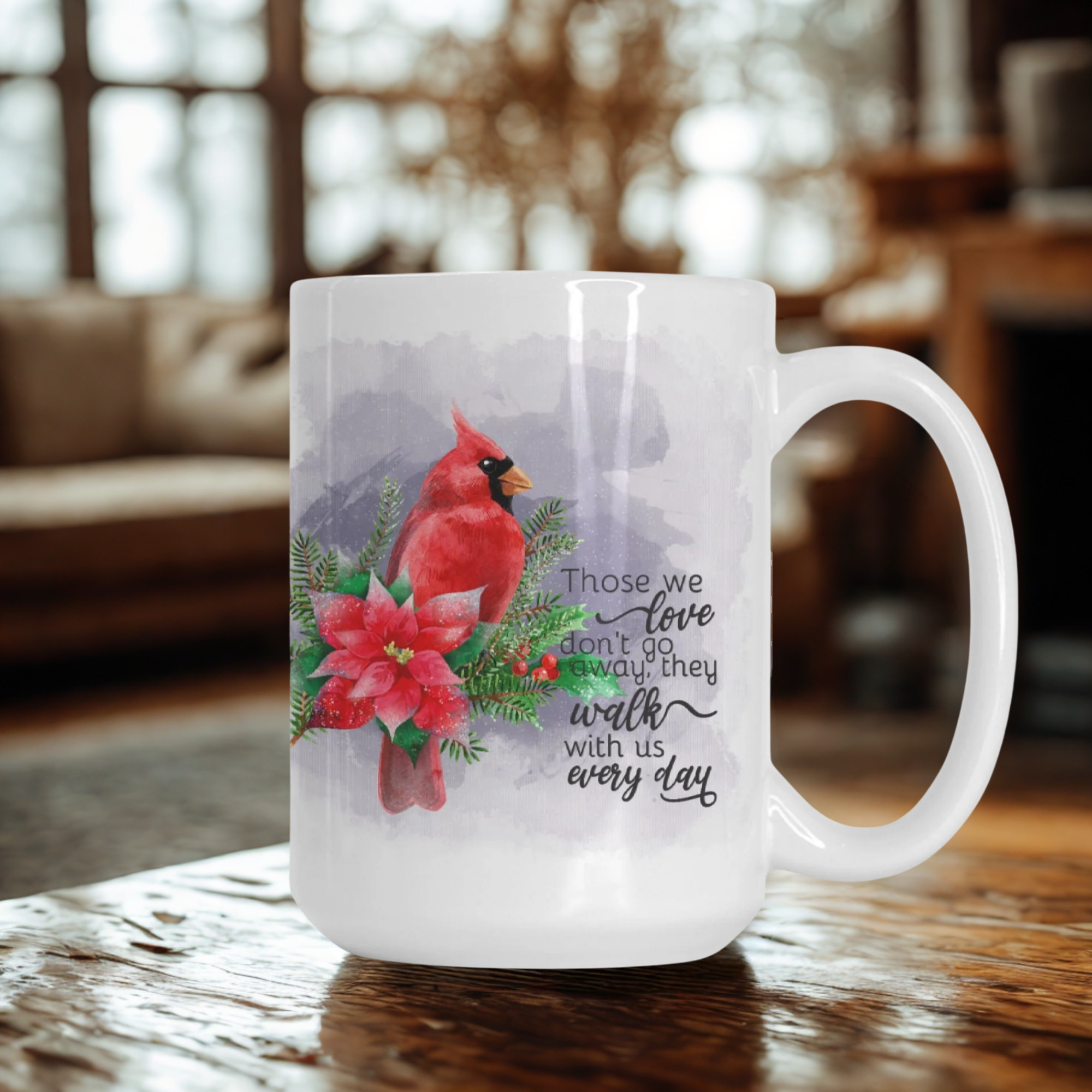 Mug with a red cardinal and poinsettia design on a wooden table.