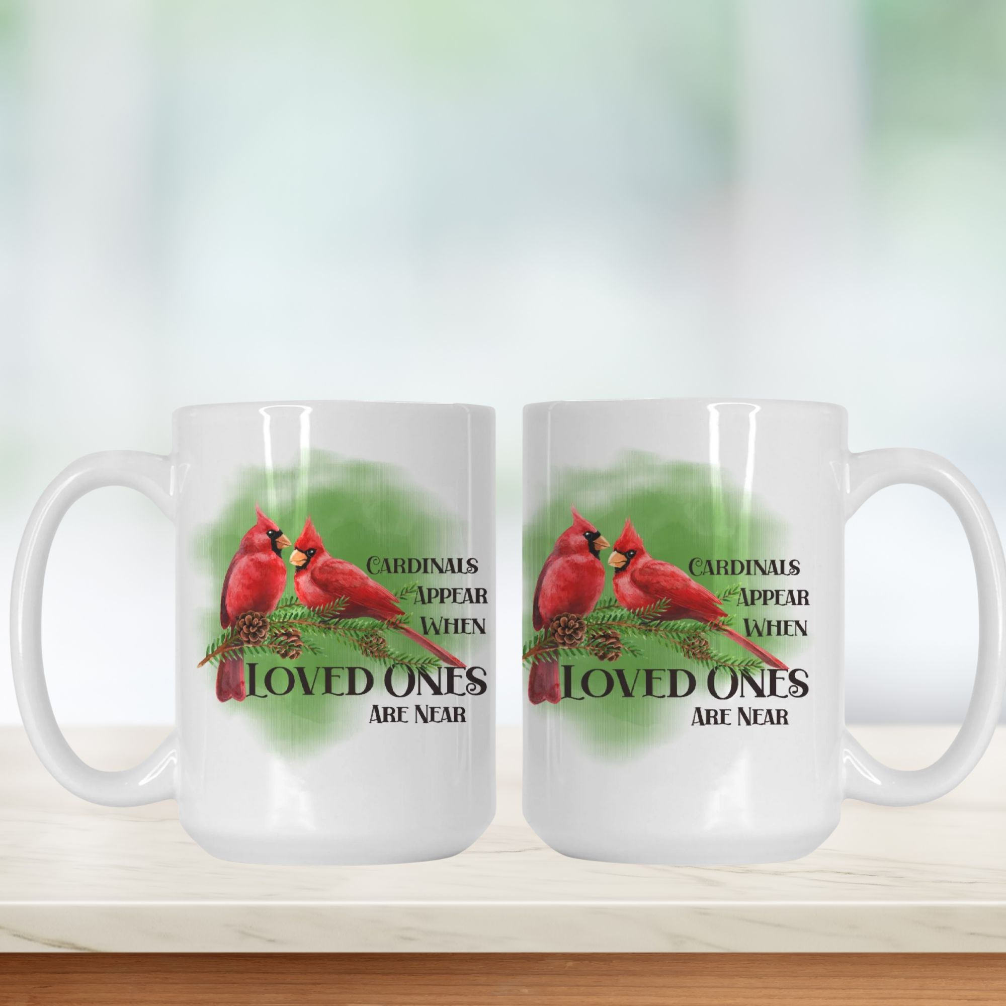 Two white mugs with red cardinals and text on a blurred background