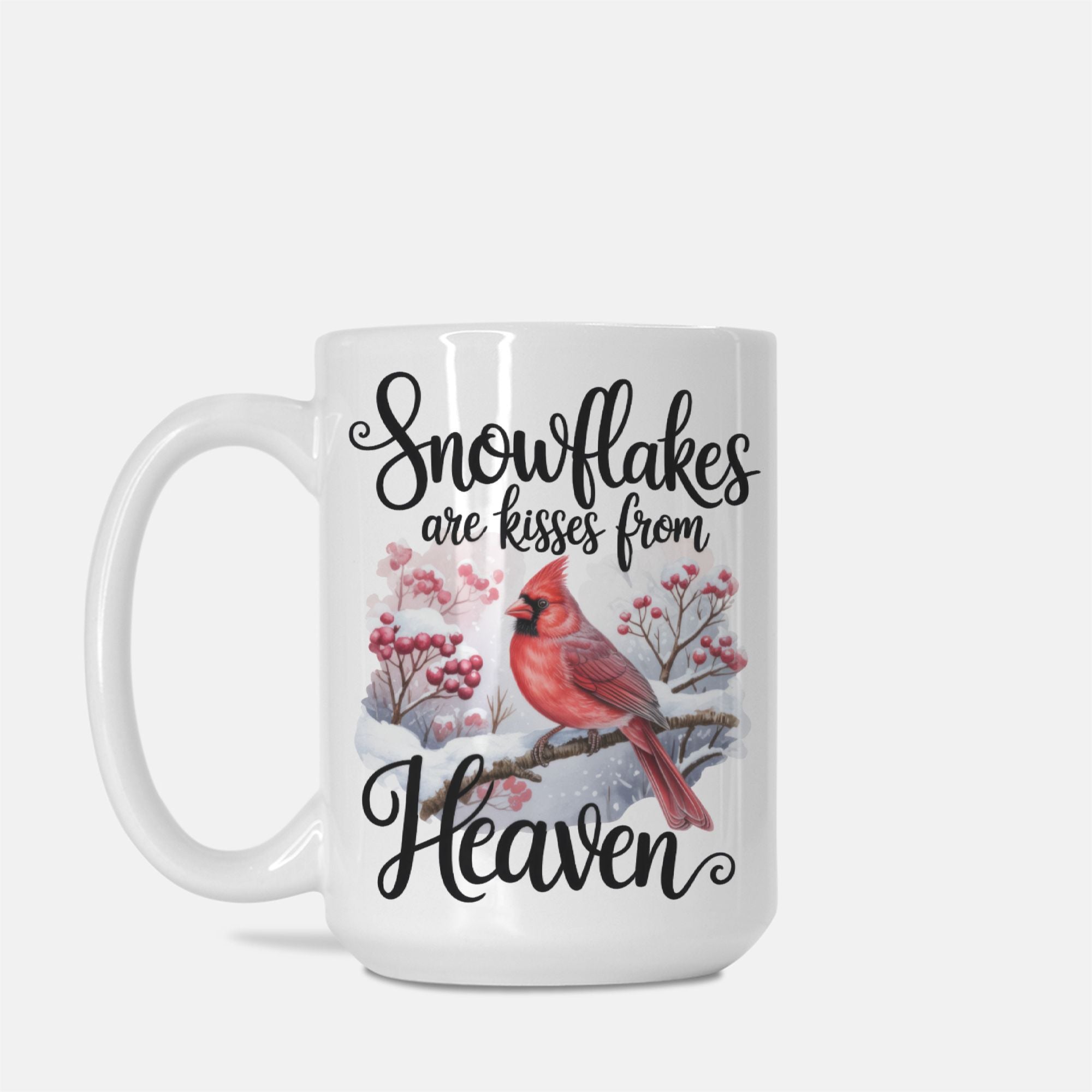 White mug with a red cardinal and snowflake design, featuring text 'Snowflakes are kisses from Heaven' on a white background.