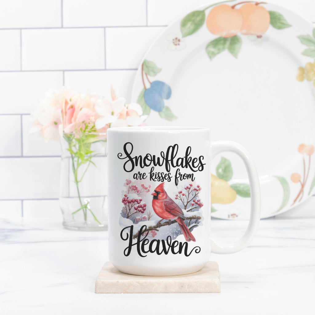 Mug with cardinal design and text on a white surface with a floral arrangement in the background