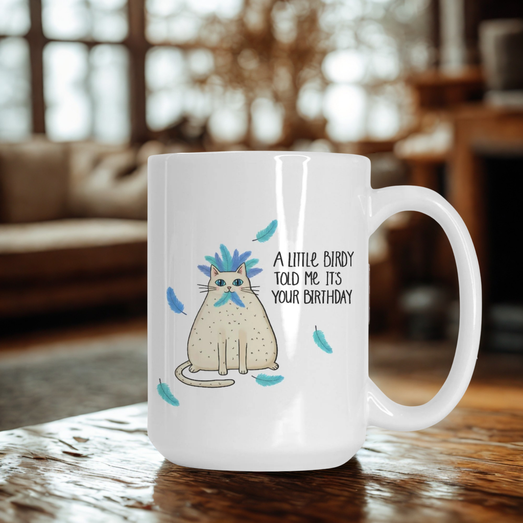 White mug with a cat illustration and text on a wooden table in a cozy room.