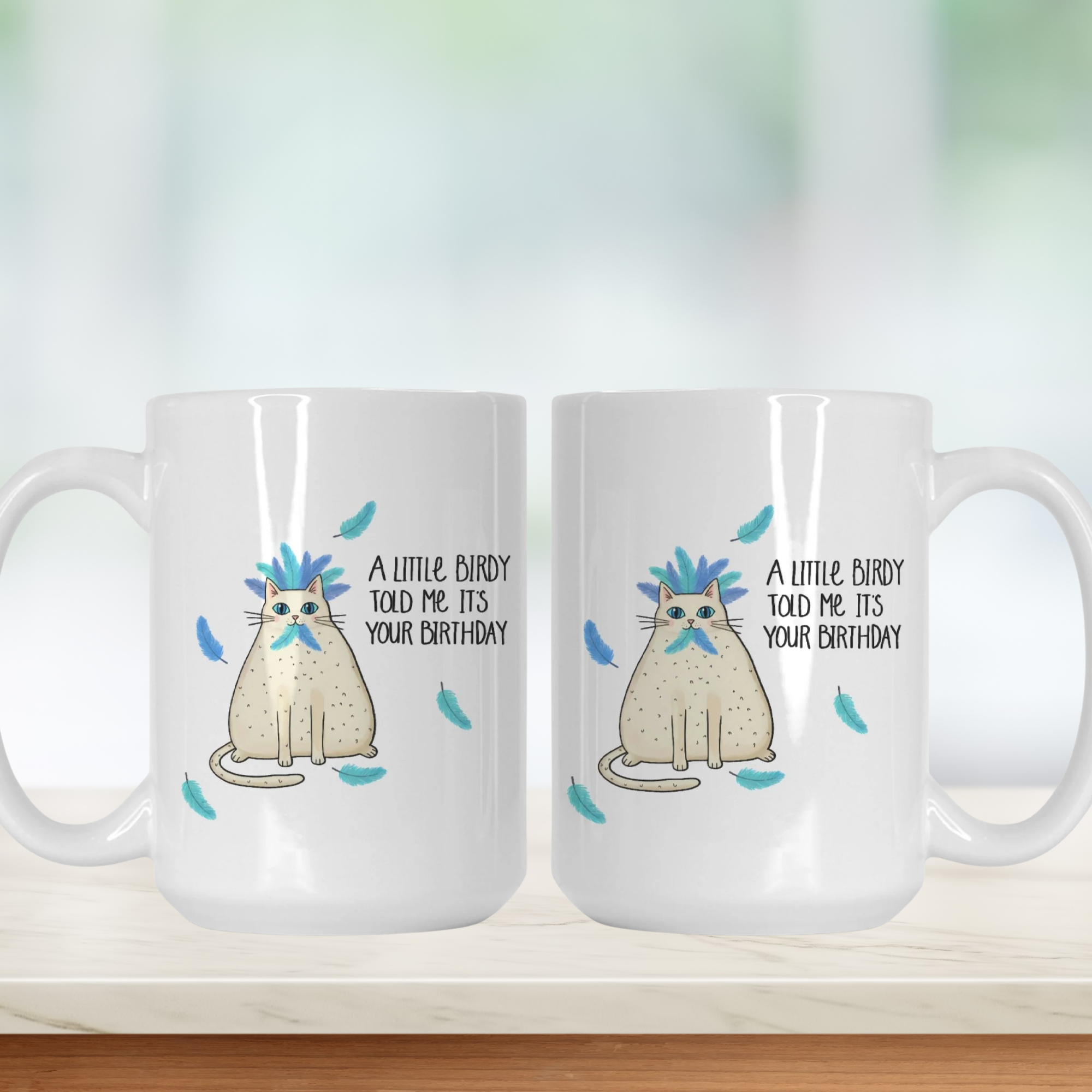 Two white mugs with a cat illustration and text on a blurred background