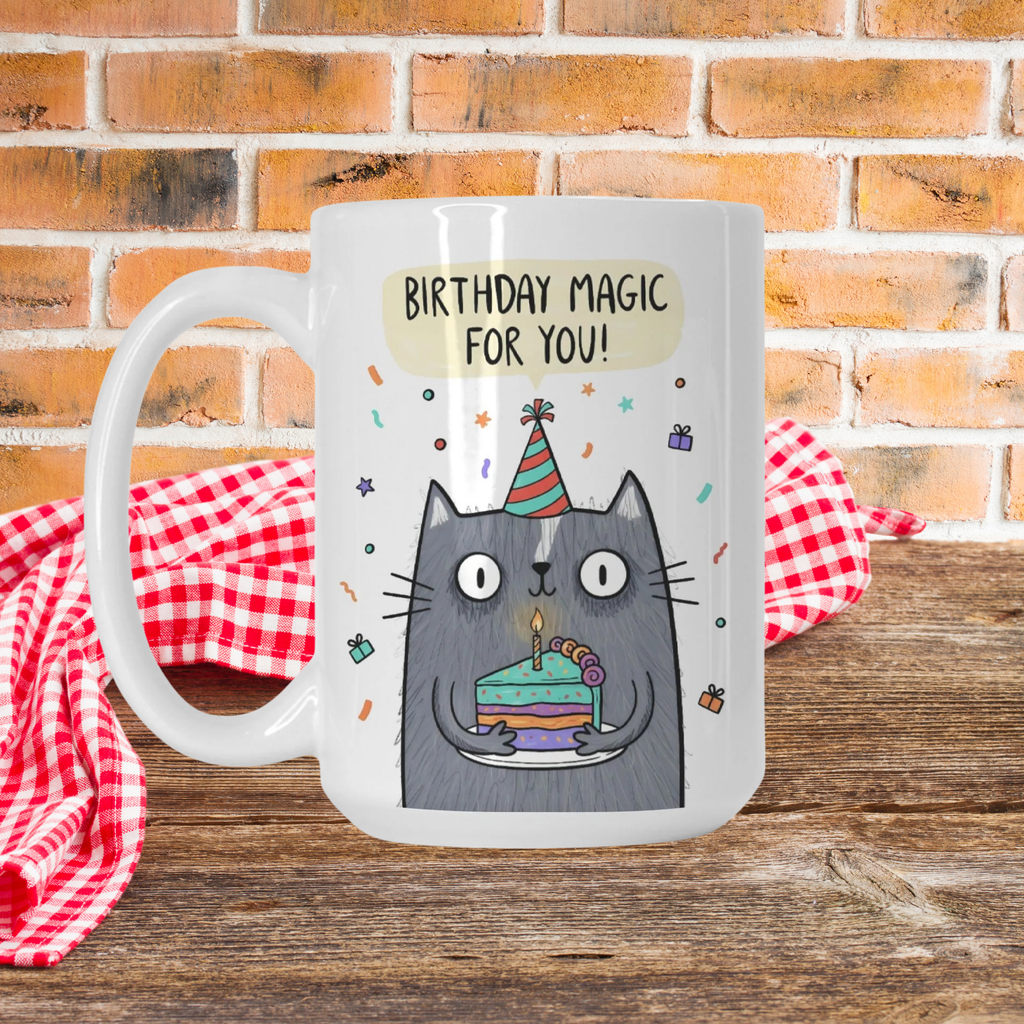 Mug with a cat illustration and 'Birthday Magic For You!' text on picnic table against a brick wall background