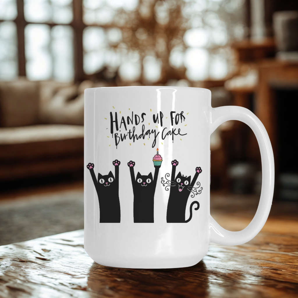 White mug with black cat illustrations and text on a wooden table.