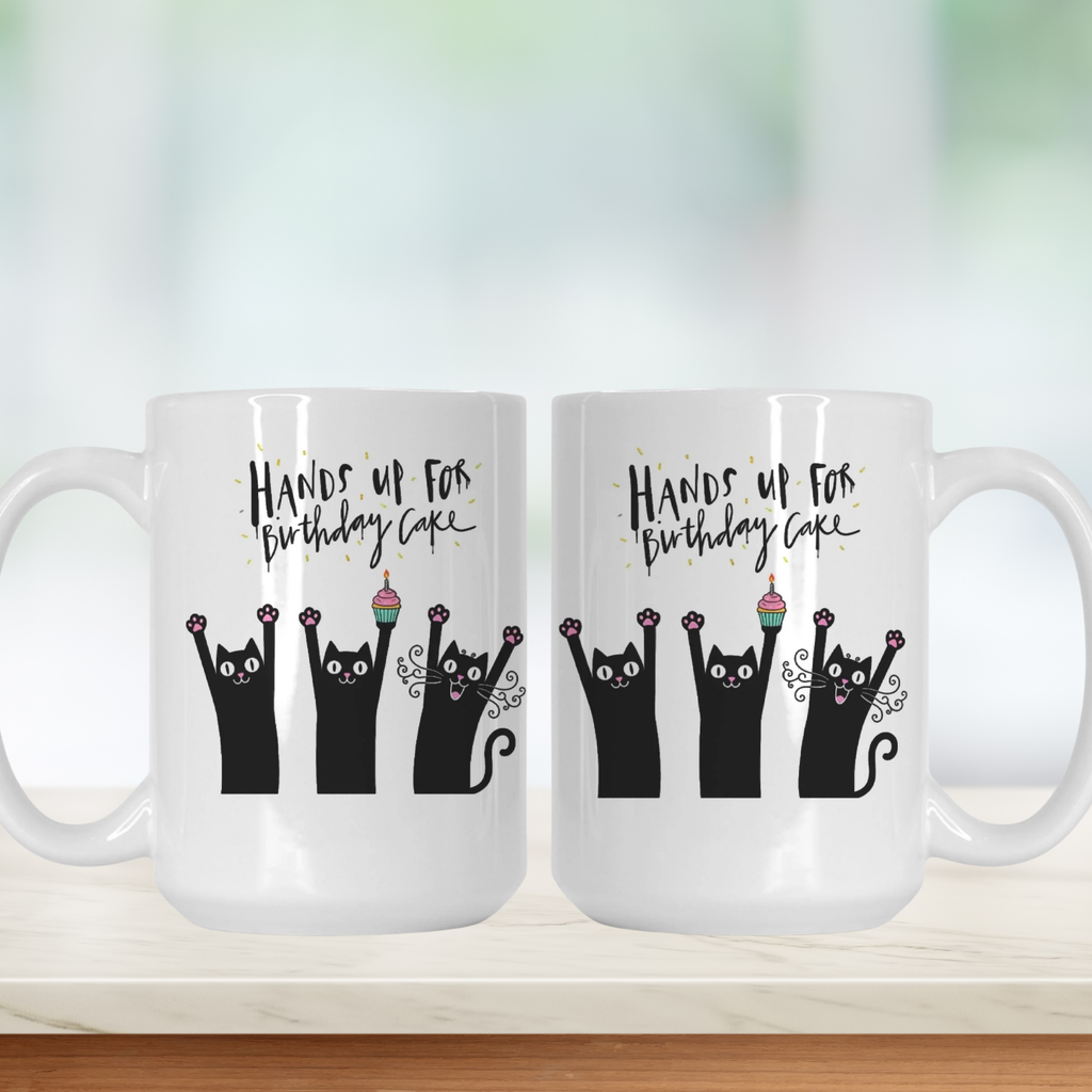 Two white mugs with black cat illustrations and text on a white background