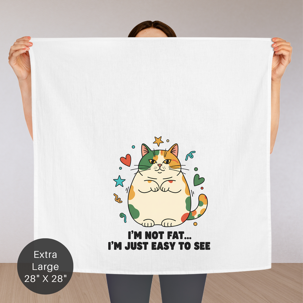 Person holding an extra large tea towel  with a cat illustration and text.