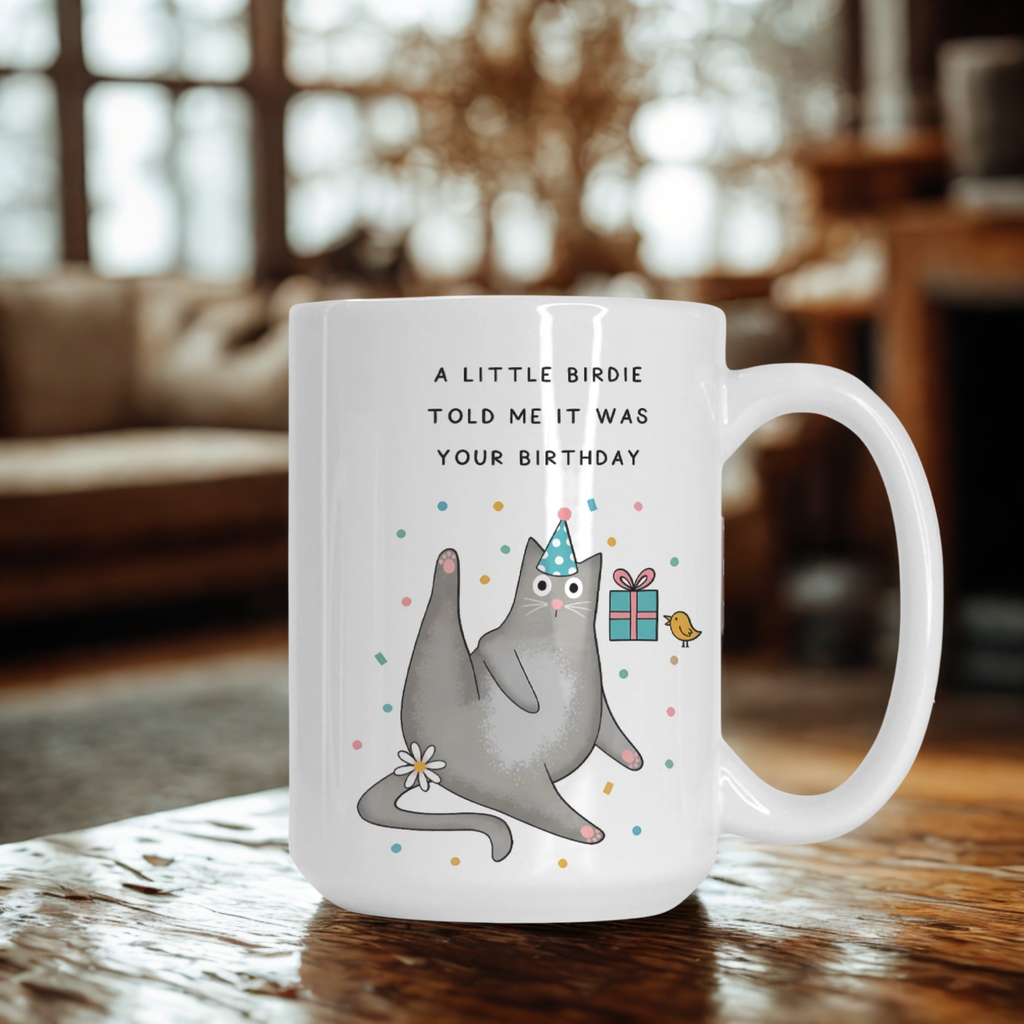 Mug with a cat illustration and birthday text on a wooden table in a living room