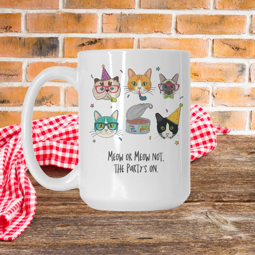 Frosted mug with cat illustrations and text on a wooden picnic table with a brick wall background