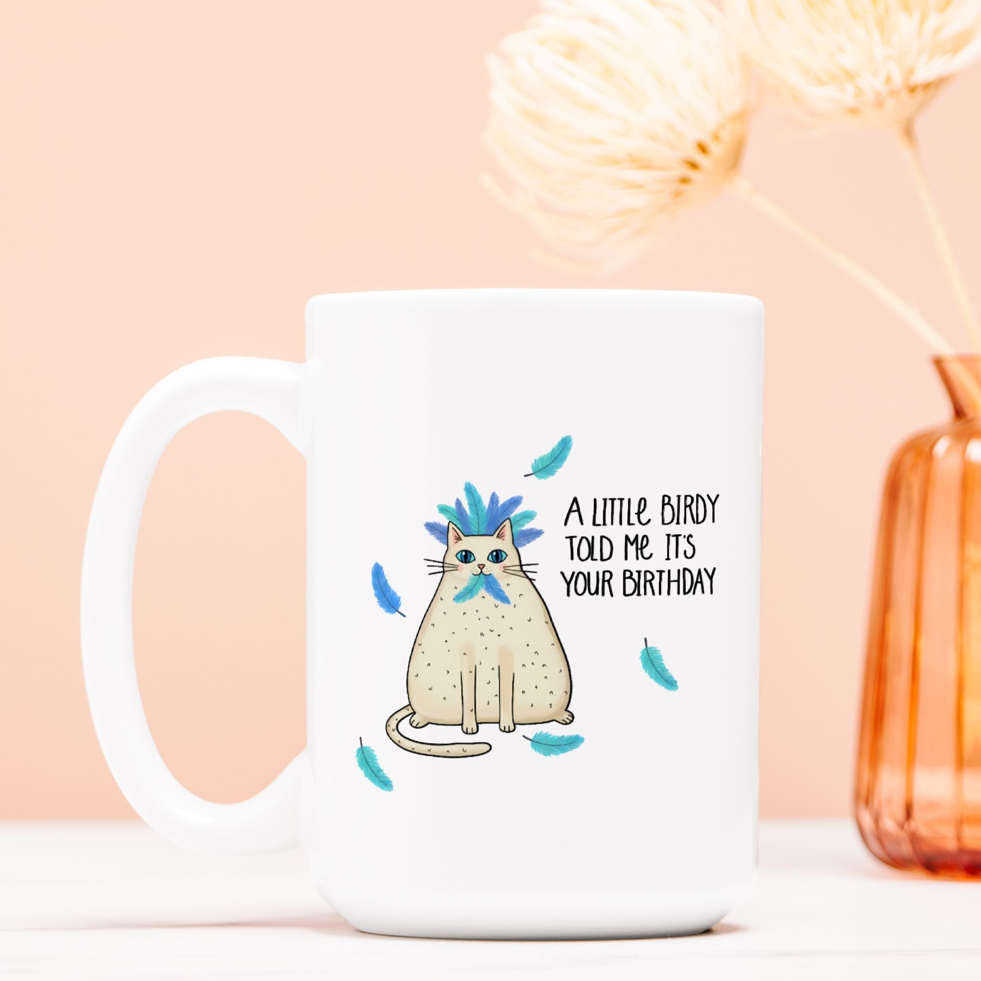 White mug with a cat illustration and text on a peach background