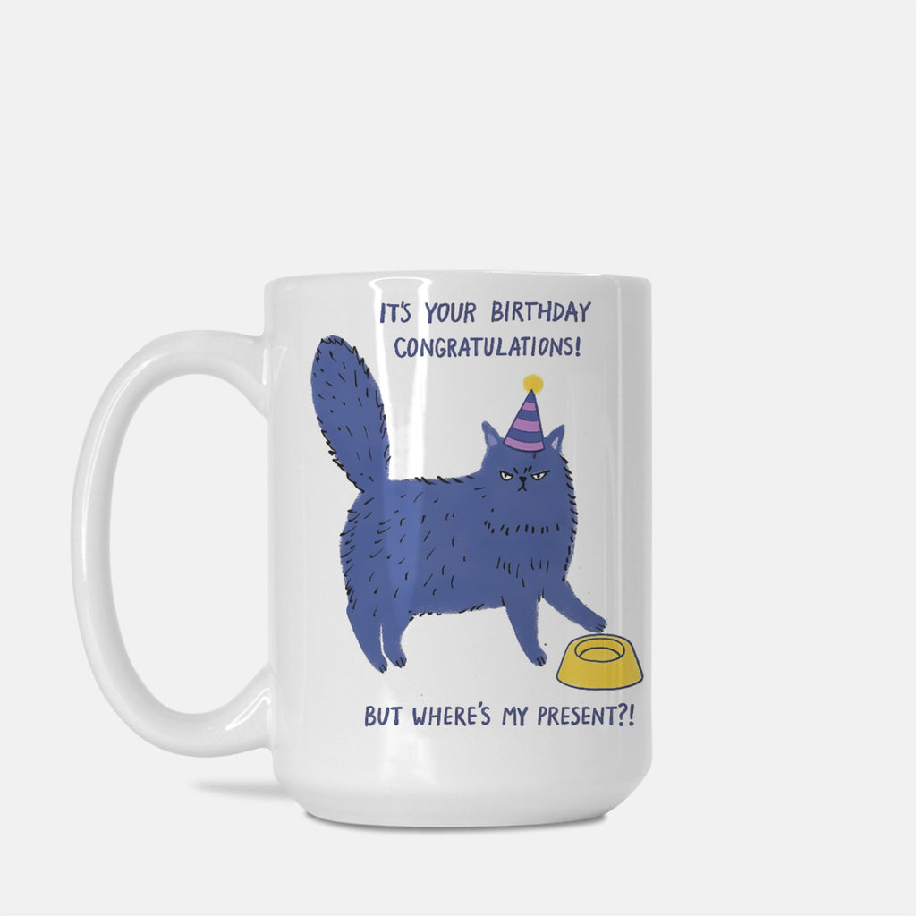 White mug with a blue cat illustration and birthday text on a white background